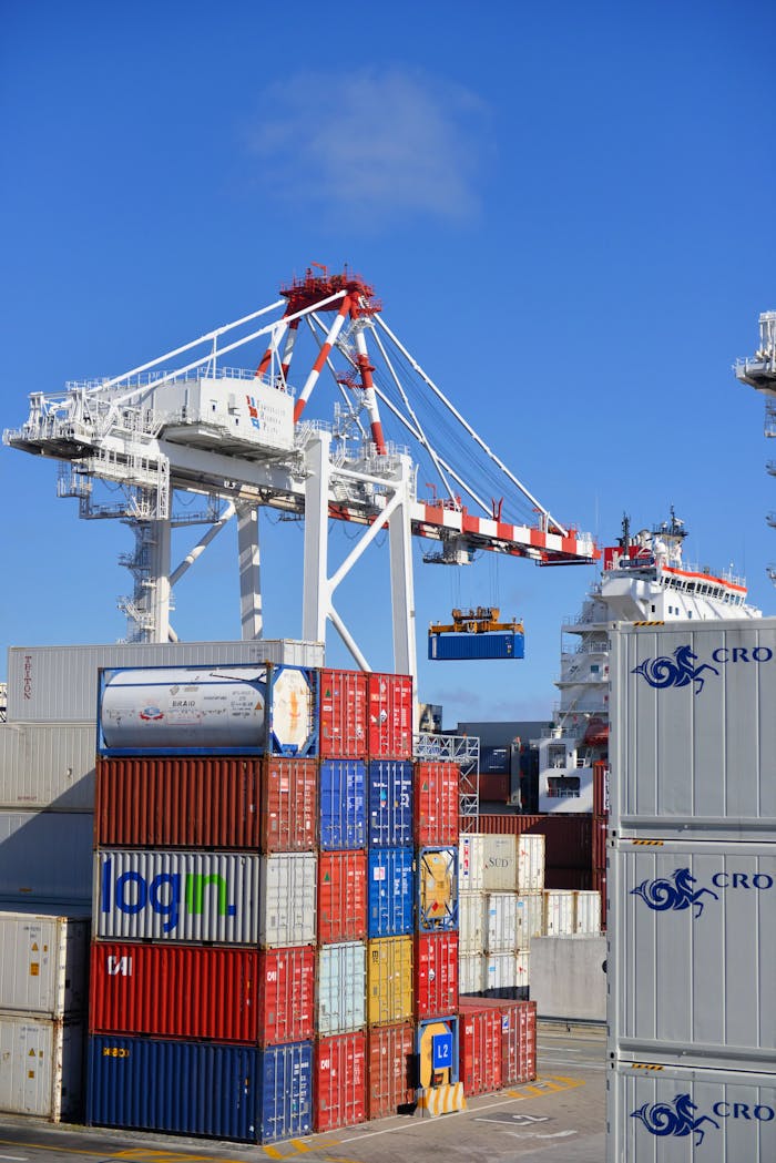 Services-02 Colorful shipping containers stacked in a busy port with cranes overhead.