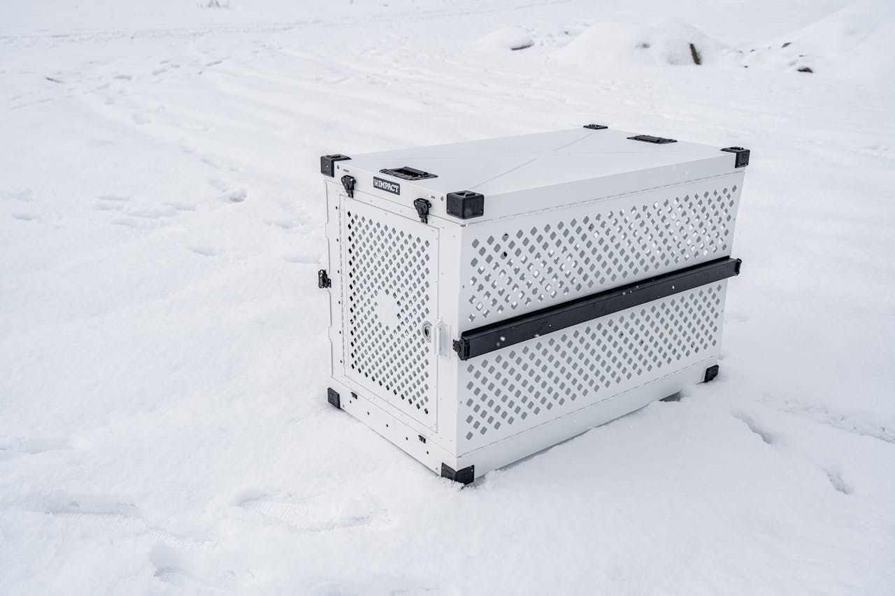 brand-01 Sturdy pet crate designed for cold conditions, shown in a snowy outdoor setting.