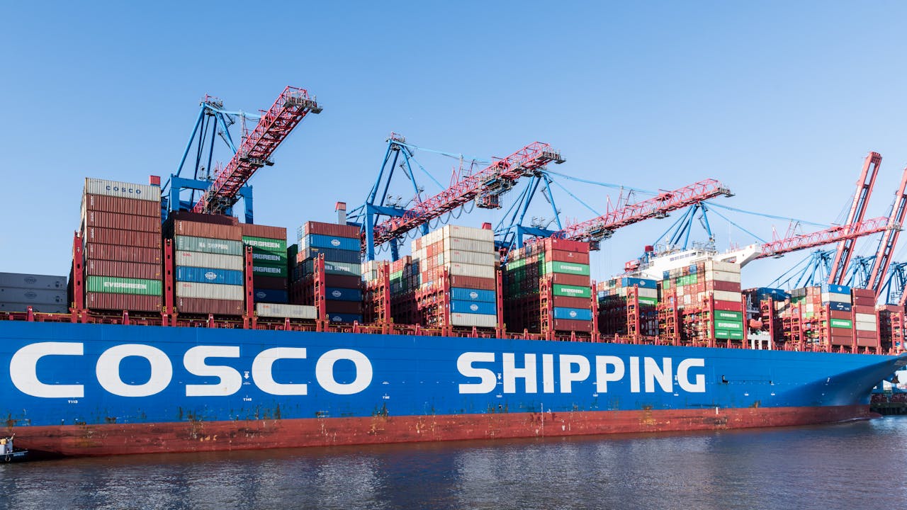 Large cargo ship at Hamburg port with cranes loading containers.